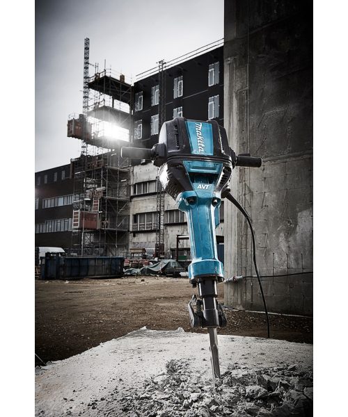 Makita HM1812 udarni čekić prikazan na gradilištu s građevinskom pozadinom.