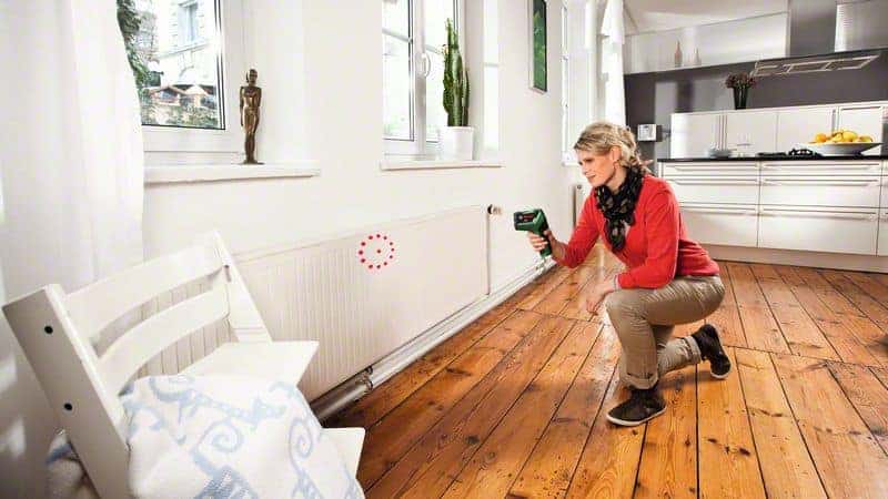 Žena koristi BOSCH PTD 1 termodetektor za detekciju toplinskih anomalija u dnevnom boravku.