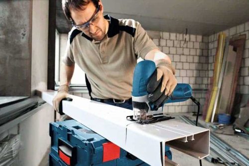 Čovjek koristi Bosch GST 90 E ubodnu pilu za rezanje metalnog profila u građevinskom prostoru.