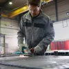 BOSCH kutna brusilica PRO GWS 14-125 S Radnik koristi BOSCH kutnu brusilicu PRO GWS 14-125 S za obradu metala u radionici.
