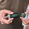 BOSCH 6-dijelni set bitova s kratkim račnim odvijačem Rukom se drži Bosch odvijač s nastavkom za bitove, prikazuje se set od šest bitova u prstenu.