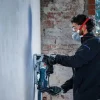 Radnik s Bosch glodalicom za utore PRO GNF20-40 na gradilištu, nosi zaštitnu masku i naočale.