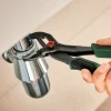 Ruka drži Bosch kliješta papagajke 250 mm s crno-zelenim držajem.
