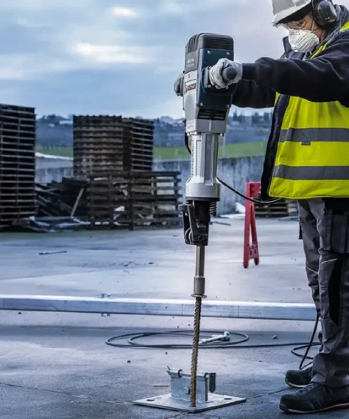 Radnik s zaštitnom opremom koristi BOSCH HEX 28 nastavak za klinove na gradilištu.