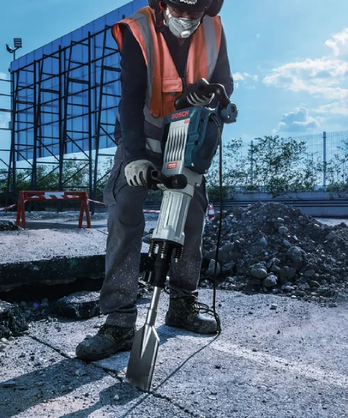 Radnik koristi Bosch HEX 30 dlijeto za asfalt na gradilištu, odjeven u zaštitnu opremu i radnu odjeću.