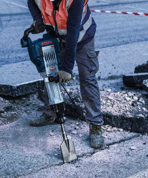 Radnik koristi Bosch HEX 30 dlijeto za asfalt na gradilištu, odjeven u sigurnosnu opremu.