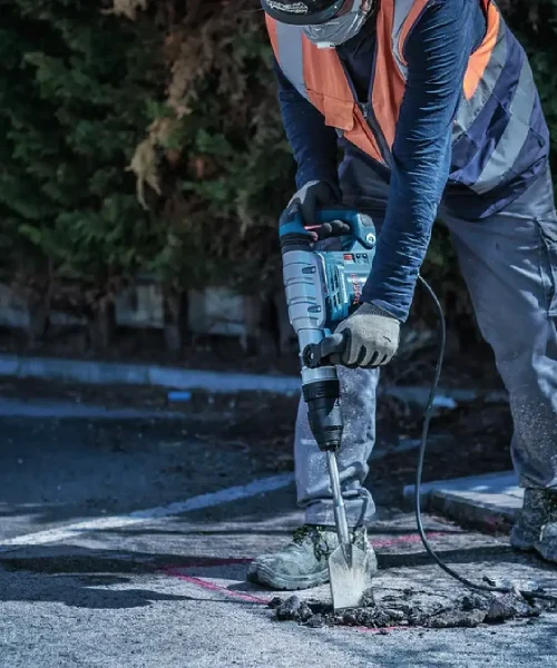 Radnik koristi Bosch SDS-max dlijeto za asfalt na gradilištu, prikazuje alat u akciji.
