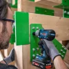 BOSCH PRO GDS18V-450P aku udarni odvijač u ruci osobe koja radi na drvenoj konstrukciji.