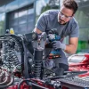 Čovjek koristi BOSCH aku udarni odvijač PRO GDS18V-450P na automobilu u radionici.