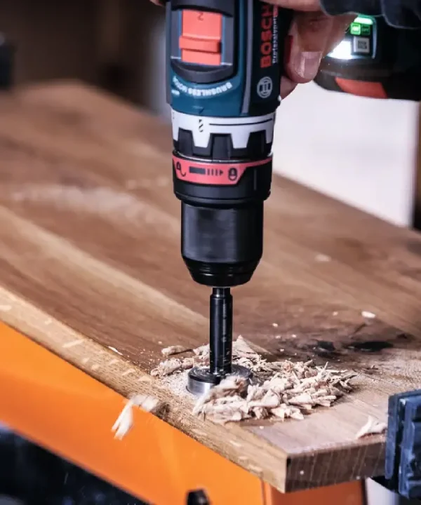 Bosch bušilica s forstner svrdlom u drvenoj ploči, alat u upotrebi.