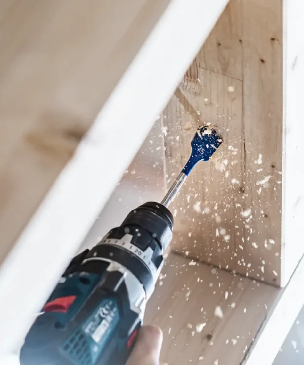Bosch alat s bušilom i pilastim nastavkom u akciji za drvo.