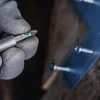 BOSCH PRO račni odvijač sa spremnikom i 12 bitova Ručni odvijač Bosch PRO s 12 bitova i spremnikom, prikazan u ruci s radnim alatom.