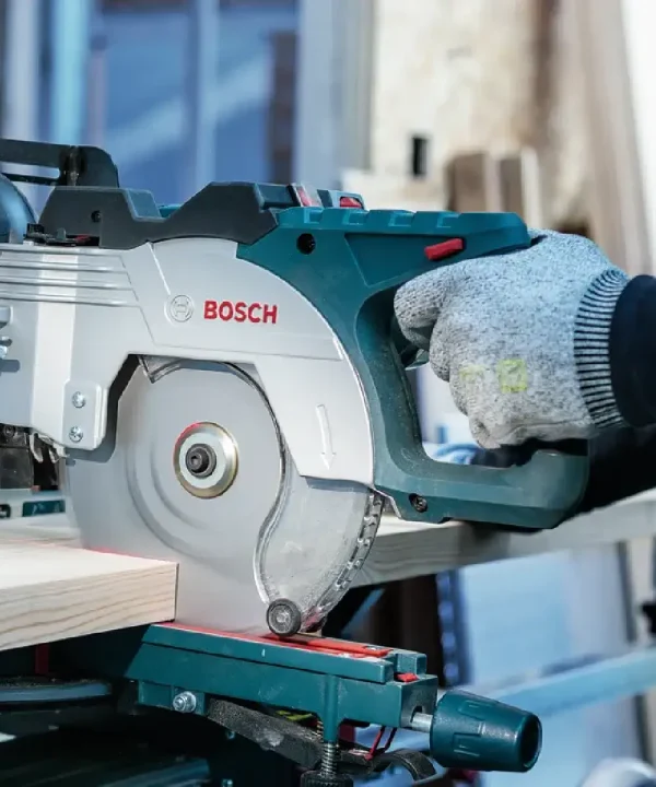 Radnik koristi Bosch akumulatorsku pilu za rezanje drva u radionici.