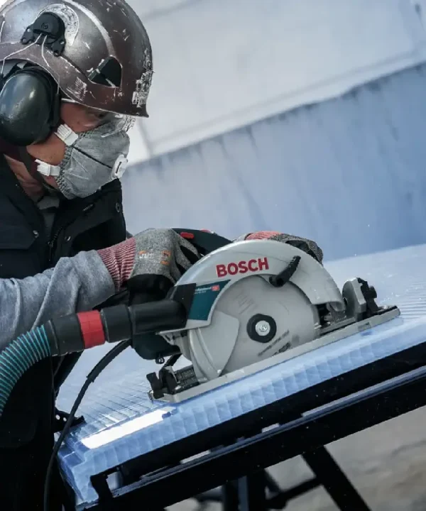 Radnik koristi Bosch kružnu pilu za rezanje metala ili drva na gradilištu.