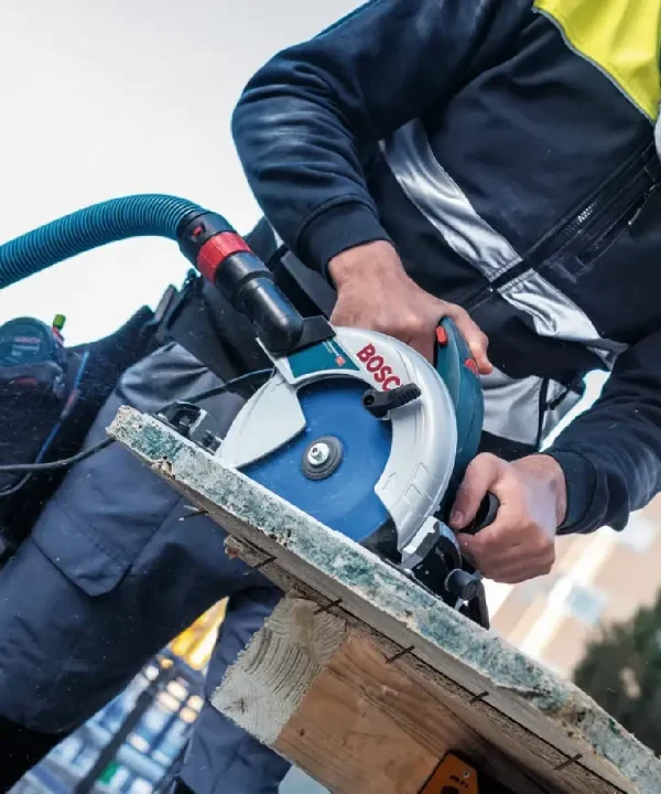 Osoba koristi Bosch kružnu pilu za rezanje drva na gradilištu.