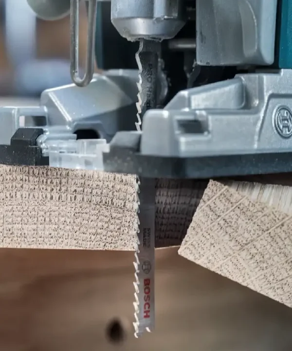 Bosch pilni list u alatnom stroju podupire rezanje tvrde mase, vidljive su drvene podloške i metalni zupčasti list.