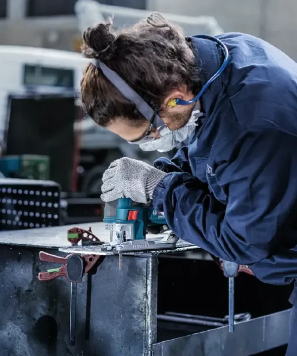 Radnik koristi utičnu ubodnu pilu za uređenje aluminijskih komada, proizvod Bosch.