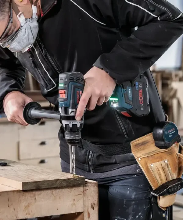 Radnik s Bosch CORE i Power Tool u uporabi pri bušenju drveta.